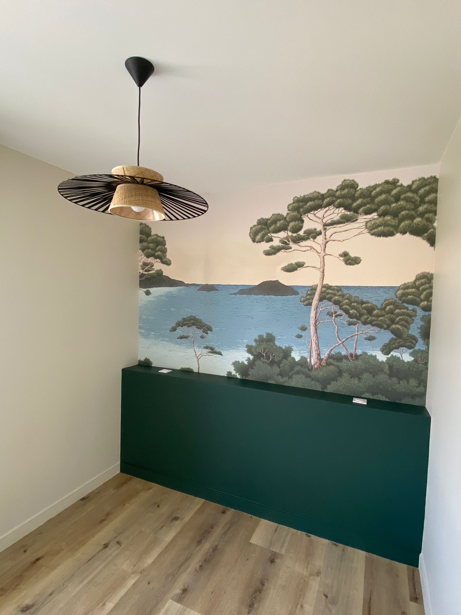 Intérieur rénové à Saint-Malo par MSPdesign alliant design moderne et éléments naturels, incluant une fresque murale aquatique et un luminaire en paille.